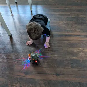 Customer photo of a child watching the dinosaur tricycle on the floor