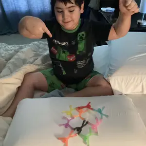 Customer photo of a child arranging colorful magnetic figures on a white tray.