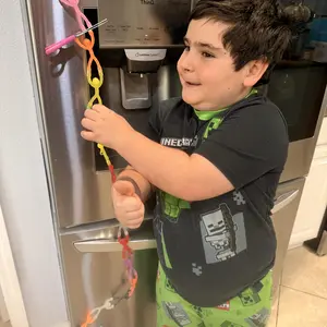 Customer photo of a child connecting magnetic figures on a refrigerator.