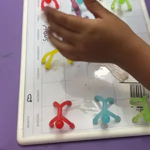 Customer photo of a child placing magnetic figures on a small whiteboard.